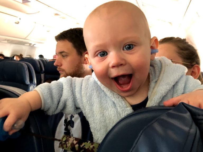 baby with earplugs on airplane