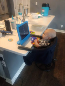 baby in highchair watching tablet