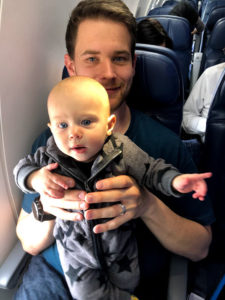 dad holding baby on plane