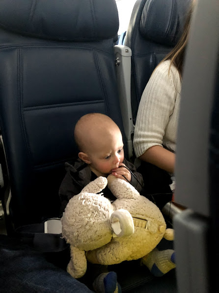 baby on airplane with toy