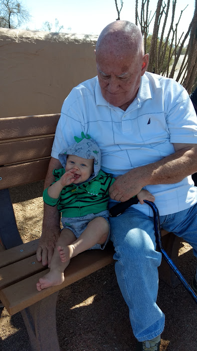 grandpa and smiling baby on park bench