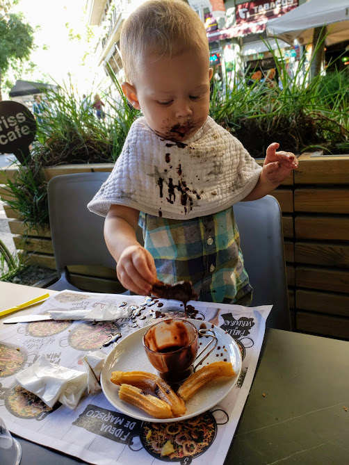 baby eating churros con chocolat in barcelona